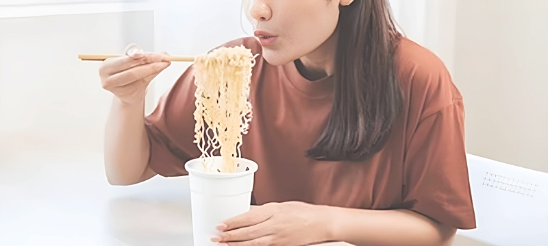 カップスターを食べる女性