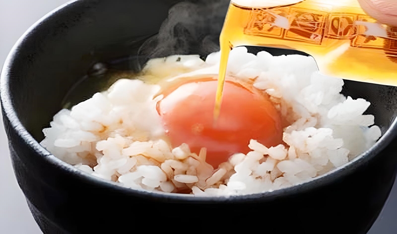 卵ごはんに納豆のタレをかける様子