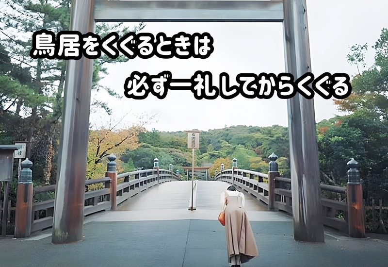 鳥居の前で1礼してくぐる女性の様子