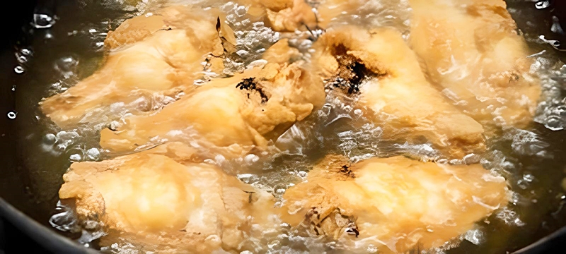 弱めの中火でじっくり手羽先を揚げる様子