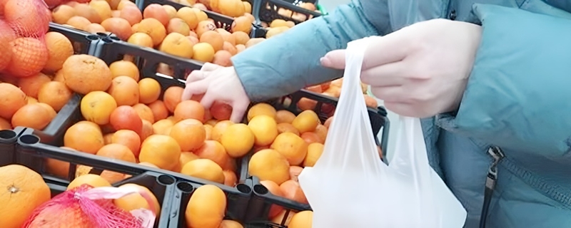 スーパーで美味しいはっさくを選ぶ女性